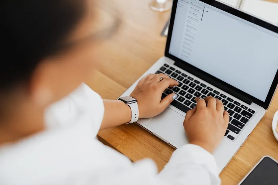 Người đang soạn email chuyên nghiệp trên laptop tại bàn làm việc